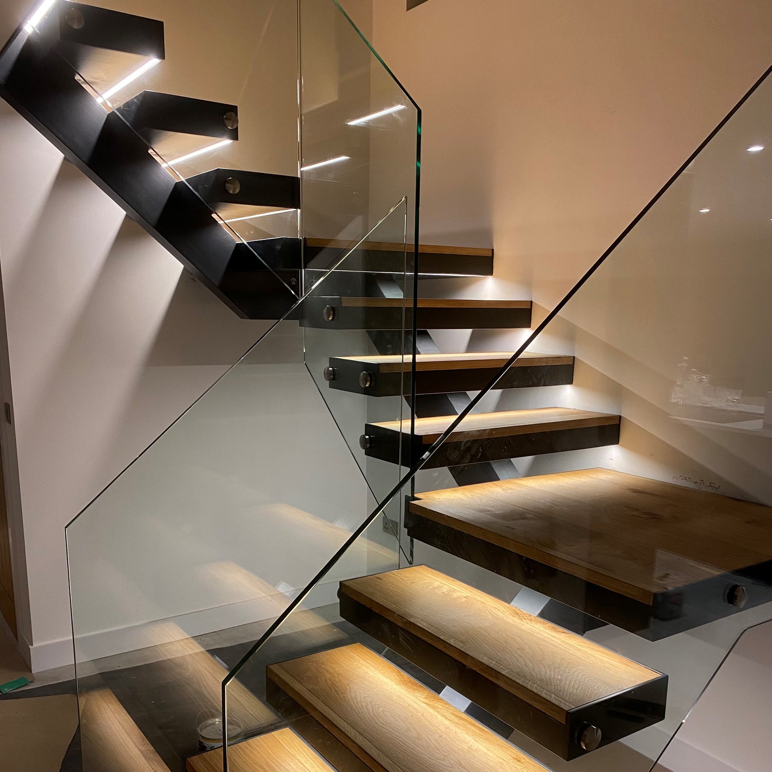 Central spine staircase, with fabricated pan shaped treads designed to fit bespoke engineered European Oak tread finishes and nosing.
Design also includes 15mm structural glass as a frameless balustrade, secured with stainless steel fixings.
Project Location: Ipswich, Suffolk
New Build Property