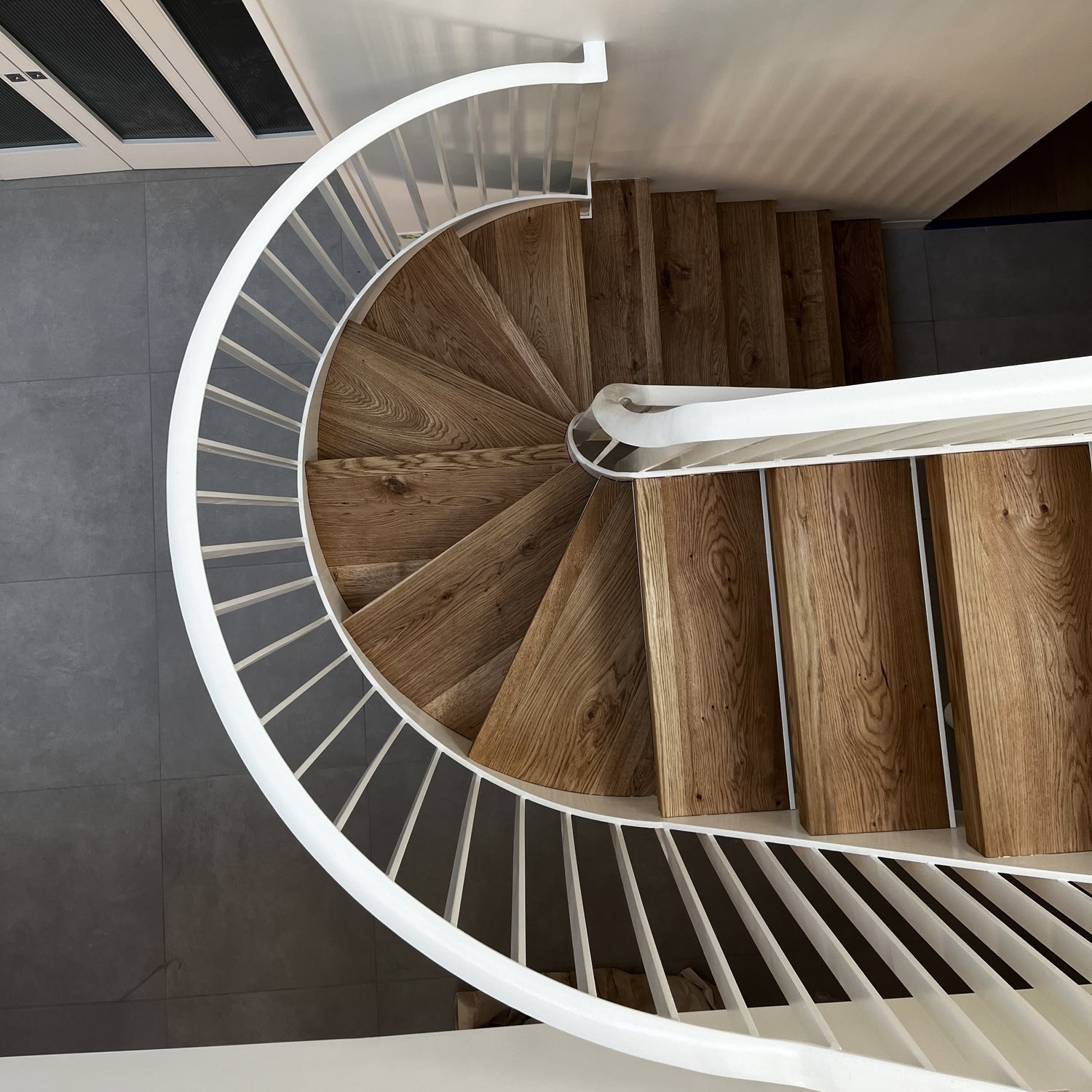 Fully fabricated helical staircase with a metal spindle deasign balustrade, and bespoke European Oak tread finishes.