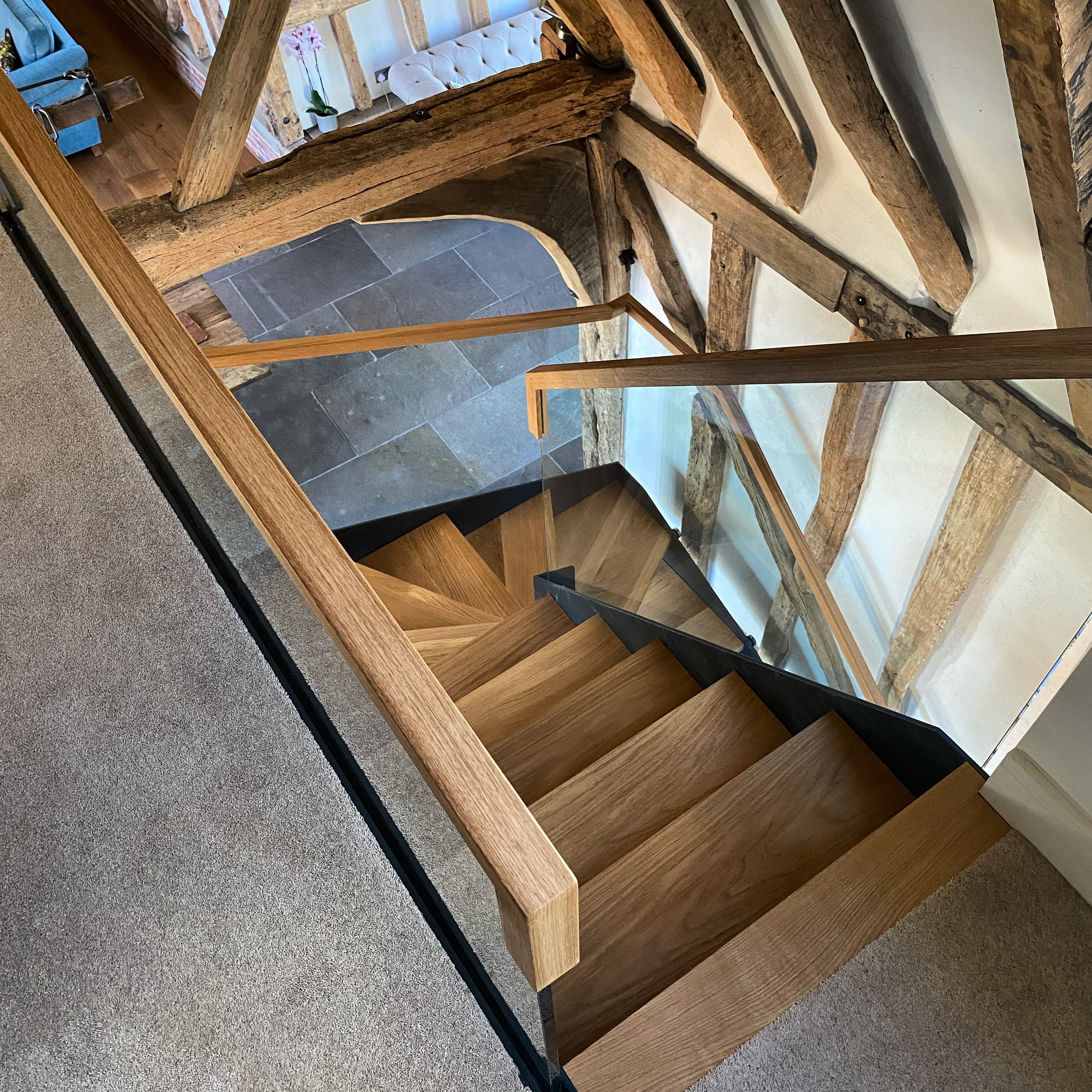 Single stringer staircase, with 15mm structural glass as a frameless balustrade, secured with stainless steel fixings. This project also included custom made squared European Oak handrail.
Project Location: Saffron Walden, Essex
Barn Conversion.
Continuous Oak Handrail