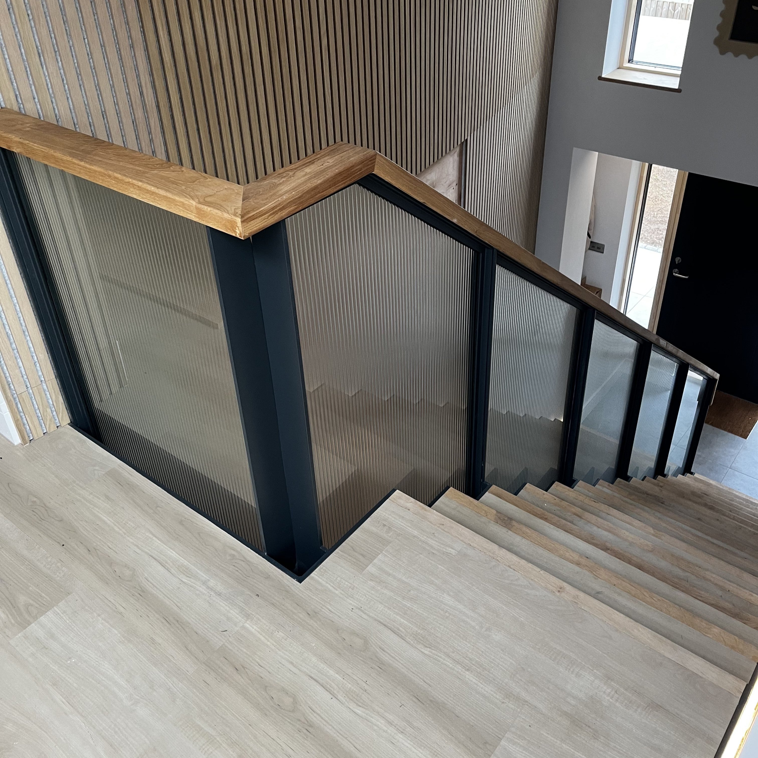 Fully fabricated feature staircase, with laminated reeded glass panels and bespoke European Oak treads and handrail. New build project in Ipswich Suffolk